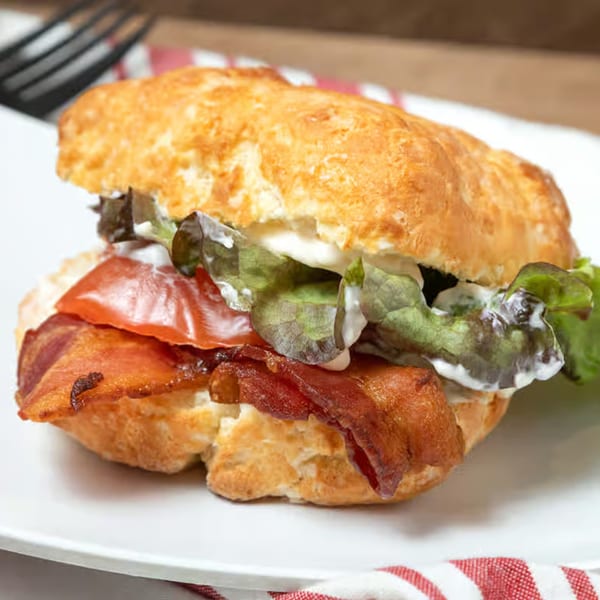 Honest Biscuits' breakfast sandwich with bacon, lettuce, tomato, and mayonnaise on a fluffy biscuit.