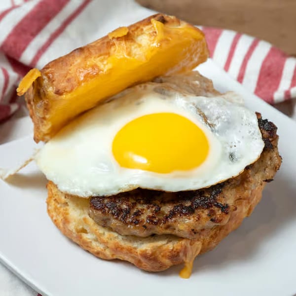 Honest Biscuits' breakfast sandwich with sausage, fried egg, and melted cheese on a biscuit.